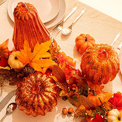 Autumn-themed table decor with glittery pumpkins and fall leaves.