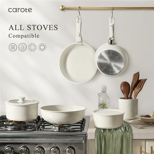 Carote cookware set on stove with hanging pans and utensils.