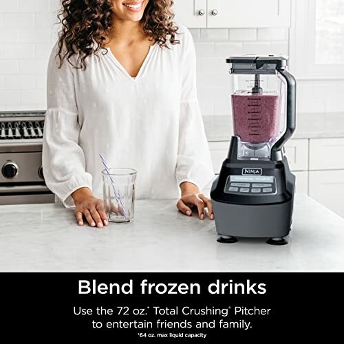 Woman using a Ninja blender with a purple smoothie.